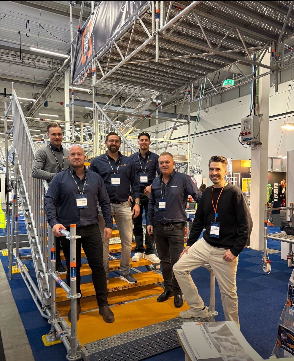 Teamet från ScaffXpert och Scafom RUX på ScaffPoint 2025, stående vid en uppmonterad ställning i montern.